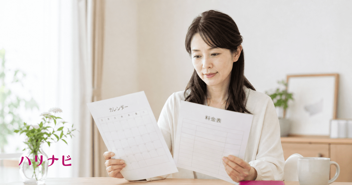 カレンダーと料金表を確認しながら通院計画を立てる女性のイメージ