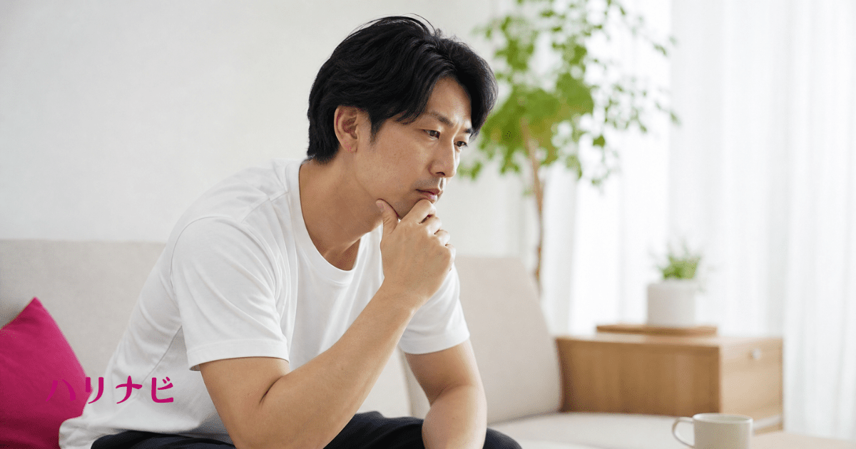 男性不妊とEDの悩みを一人で抱え込む30代男性が自宅で考え込んでいる様子