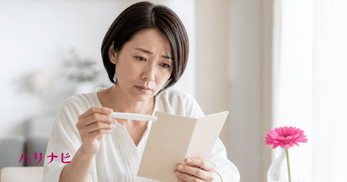 妊娠検査薬と母子健康手帳を手に不安そうな表情を浮かべる女性のイメージ