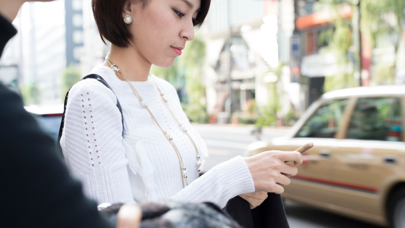 スマホで美容鍼サロンを探している女性